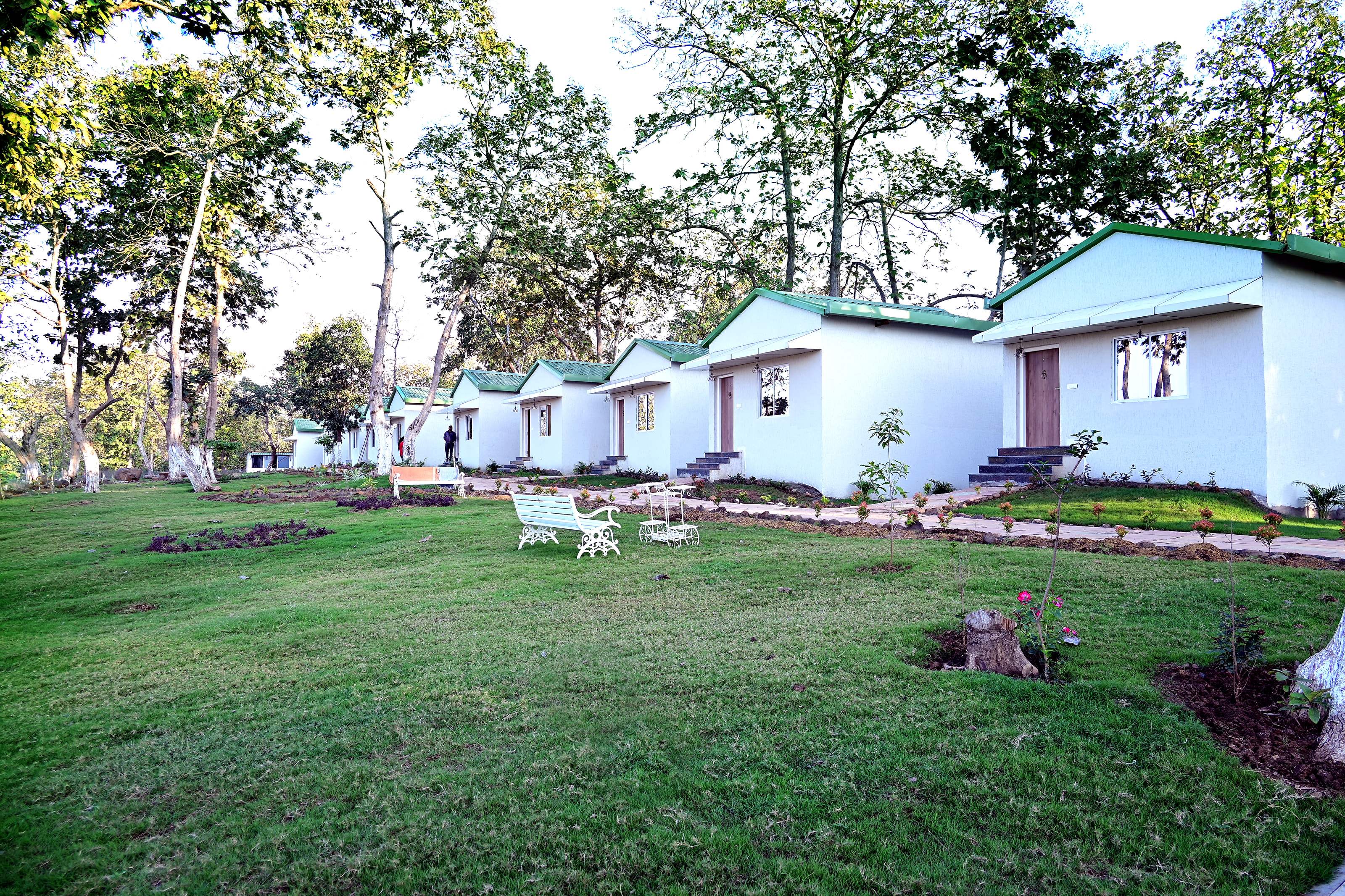 Cottages along the edge of a wide lawn with garden benches